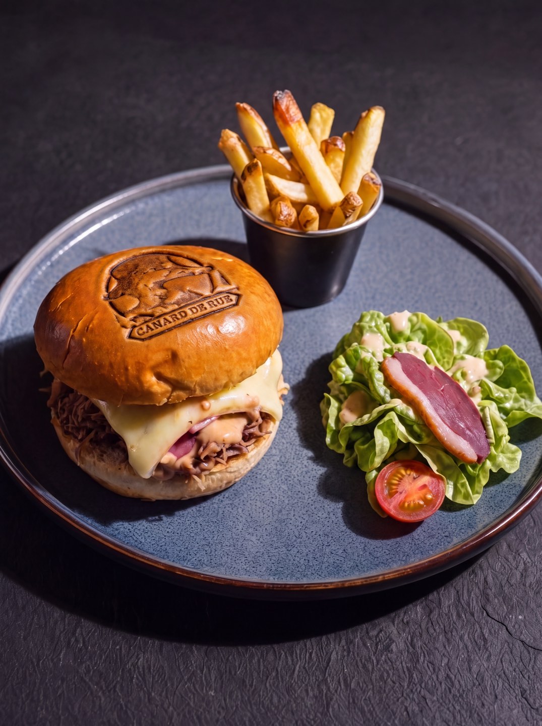 Burger au canard effiloché avec le logo marqué sur le pain, servi avec frites et salade